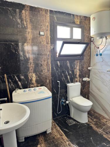a bathroom with a toilet and a sink at Helnan portfouad chalet in Chantier Island