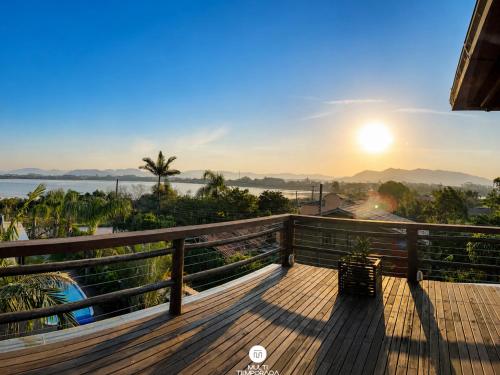 a view from the deck of a house with the sunset at Ibiraquera Life in Praia do Rosa