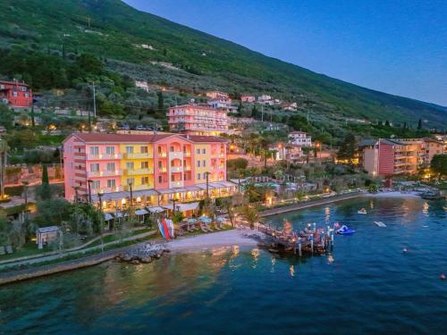 a view of a city with a boat in the water at Belfiore Park Hotel 4Stars Superior "Adults Only" in Brenzone sul Garda
