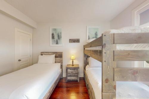 a bedroom with two bunk beds and a lamp at Rivergrass by Property Valet in Blue Mountains