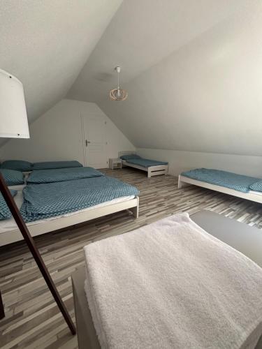 a attic bedroom with two beds and a rug at Chata pod hradom in Divín