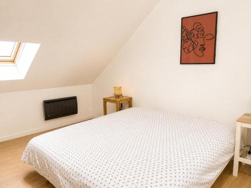a bedroom with a white bed and a television at Bel appartement 2 chambres in Ham
