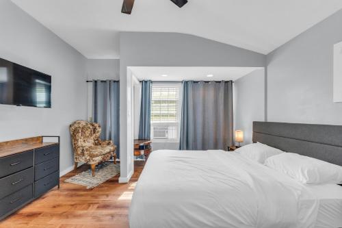 a bedroom with a bed and a chair and a television at Stay with Jay - Quinta Suite in Cleveland