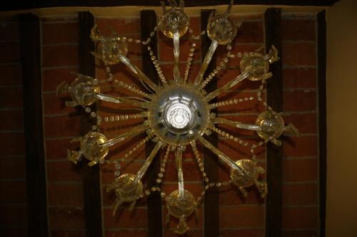 a large gold chandelier hanging from a brick wall at I Malpensanti del Trieste in Monticelli dʼOngina