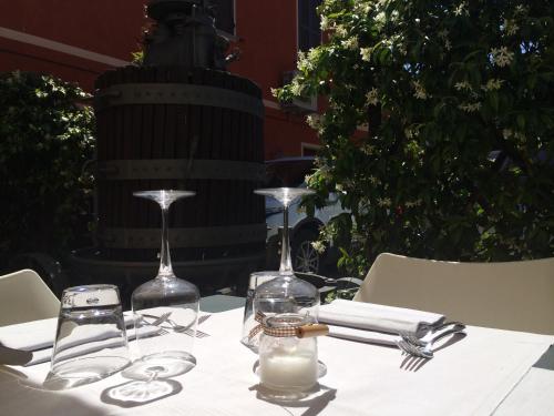 a table with a white table cloth and two wine glasses at I Malpensanti del Trieste in Monticelli dʼOngina