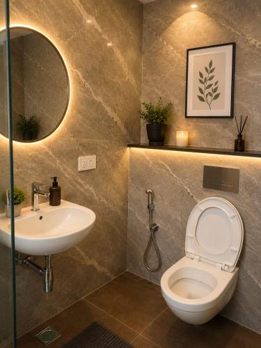 a bathroom with a sink and a toilet and a mirror at sea stay inn in Mahabalipuram