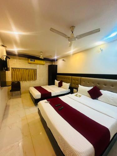 a hotel room with two beds in a room at Hotel Bkc Palace Kurla in Mumbai