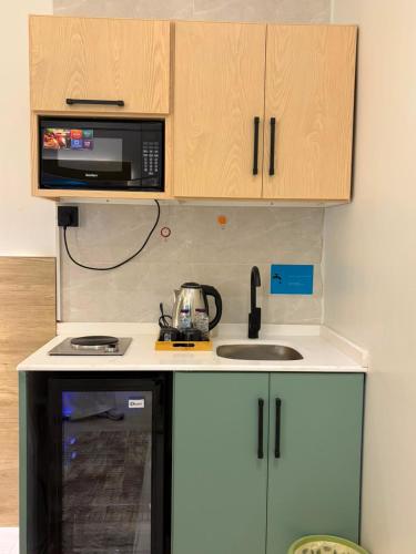 a kitchen with a sink and a microwave at لين سويت in Khamis Mushayt