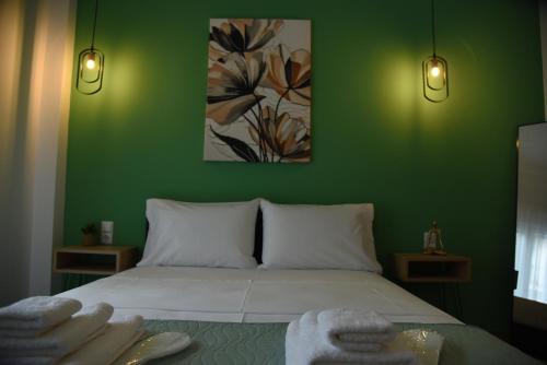 a green bedroom with a bed with towels on it at Luxury Green Apartment in Serres