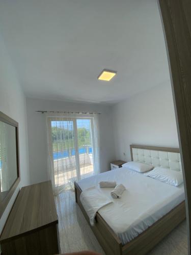 a bedroom with a large bed and a window at Iljon Apartments in Tushemisht