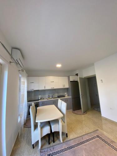 a kitchen and dining room with a table and chairs at Iljon Apartments in Tushemisht