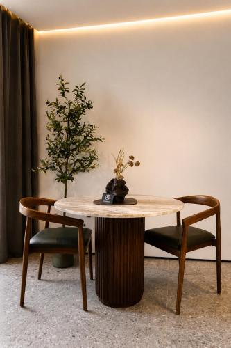 a table and two chairs with a potted plant on it at Valverda - Boutique Apartments in Grödig
