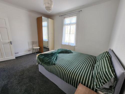 a bedroom with a bed and two windows at The Moonflower in Grays Thurrock