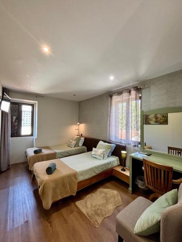 a large room with two beds and a desk at Casa do Avô Grande in Esposende