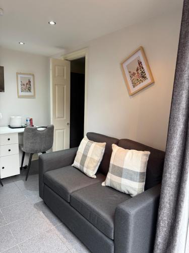 a grey couch with two pillows in a living room at Self contained Coventry in Coventry