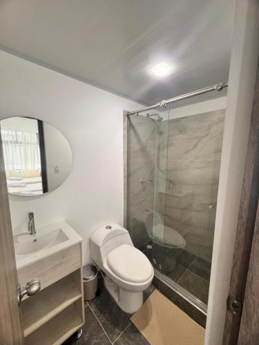 a bathroom with a toilet and a sink and a shower at Zentio Hotel in Bogotá