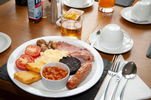 a plate of food with meat and vegetables on a table at Gwesty Seren Hotel in Blaenau-Ffestiniog