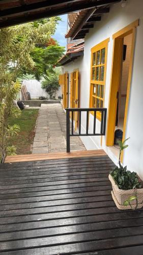 a wooden walkway leading to a building with yellow doors at Villa Dolce Mare in Arraial do Cabo