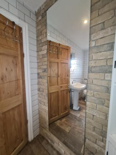 a bathroom with wooden doors and a white toilet at The Carnation in Grays Thurrock