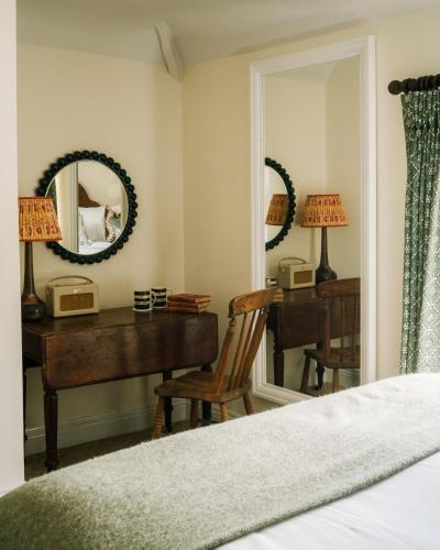 a bedroom with a desk and a mirror at The Great Decoy in Hurstbourne Tarrant