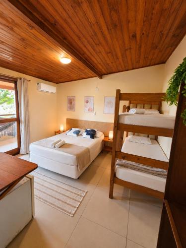 a bedroom with two bunk beds and a wooden ceiling at Pousada La Cabana in Itacaré