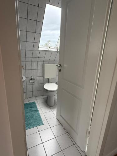 a bathroom with a toilet and a window at Wiesenhuus in Sankt Peter-Ording