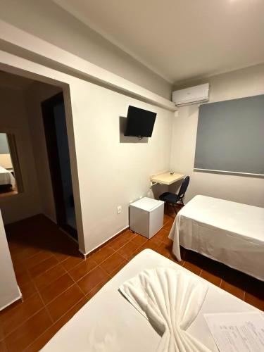 a hotel room with two beds and a flat screen tv at Bravo City Hotel Campinas in Campinas