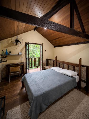 a bedroom with a bed and a wooden ceiling at Chalé Sonho Meu Penedo in Itatiaia