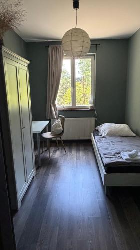 a bedroom with a bed and a desk and a window at Rózsa Vendégház INGYENES PARKOLÁSSAL in Nagykovácsi