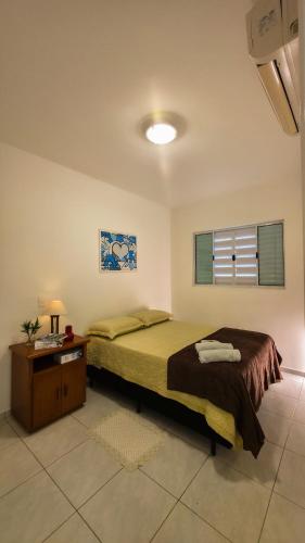 a bedroom with a bed and a table and a window at Aconchego e praticidade no centro histórico in Itu