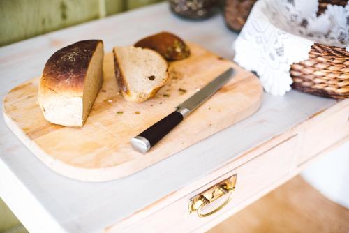 a cutting board with bread and a knife on a counter at Urshult Hotell in Urshult