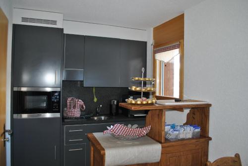 a kitchen with black cabinets and a counter in it at Les Petits Mélèzes in Crans-Montana
