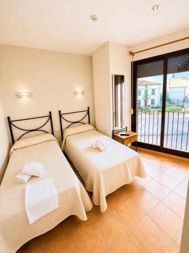 two beds sitting next to each other in a room at Hostal Restaurante Portell in Portell de Morella