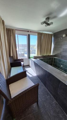 a room with a hot tub with chairs and tables at El Palmar in San Antonio de Arredondo