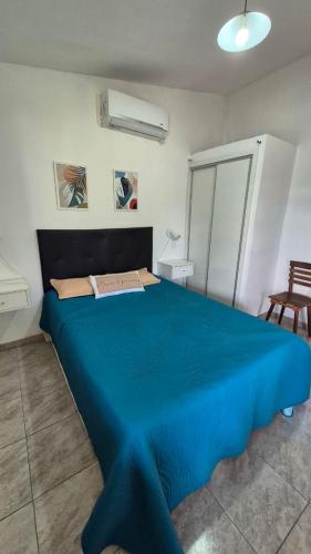 a large blue bed in a white room at El Palmar in San Antonio de Arredondo
