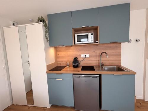 a small kitchen with a sink and a microwave at Cozy & air-conditioned studio in Vannes