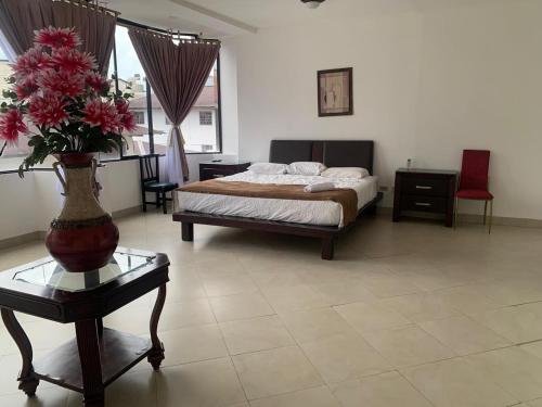a bedroom with a bed and a vase with flowers on a table at Christian Palace in Tena