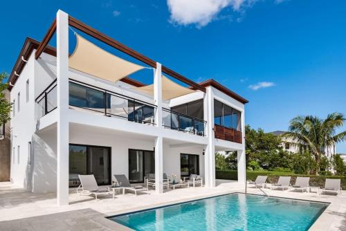 a villa with a swimming pool and a house at Bora 4 BR Villa in Long Bay Hills