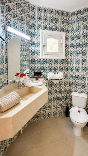 a bathroom with a toilet and a sink at Hôtel Archipel in Monastir