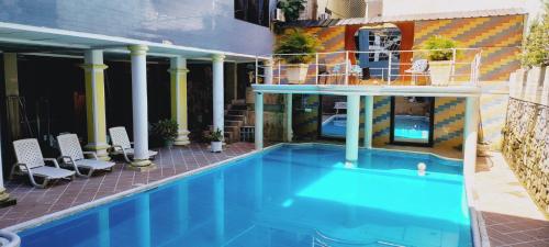a large blue swimming pool in front of a building at Christian Palace in Tena