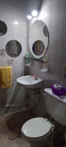 a bathroom with a toilet and a sink and mirrors at Alojamiento en Malargue in Malargüe