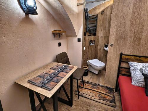 a room with a table and a bathroom with a toilet at Podziemne Arkady-nocleg centrum blisko dworca in Gniezno