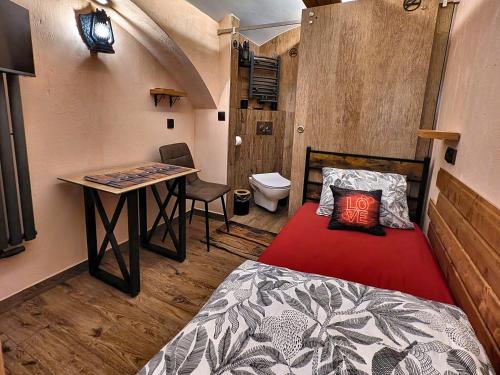 a bedroom with a bed and a desk and a table at Podziemne Arkady-nocleg centrum blisko dworca in Gniezno