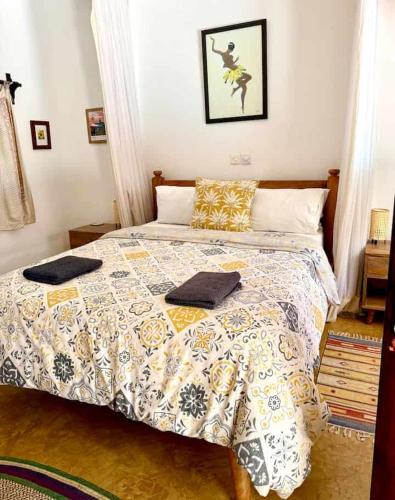 a bedroom with a bed with a comforter on it at Casa del Mar Diani in Diani Beach