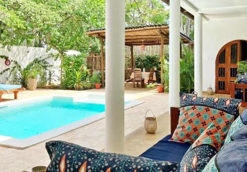 a living room with a couch and a swimming pool at Casa del Mar Diani in Diani Beach
