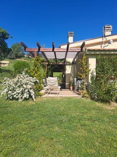 a yard with two chairs and a pergola at Calliope vacanze in Terni
