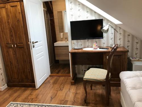 a room with a desk with a television and a bed at CenterCity Apartments in Prešov