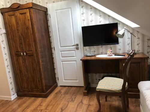 a room with a desk with a tv and a door at CenterCity Apartments in Prešov