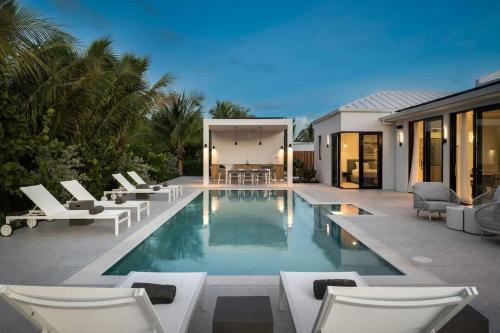 a swimming pool with lounge chairs and a house at Villa Seadream - Upper East Side Enclave #16 in Long Bay Hills