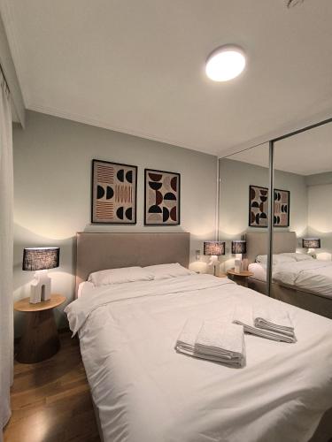 a bedroom with a large white bed and two tables at Suite Room 33 Ioannina - Near airport in Ioannina